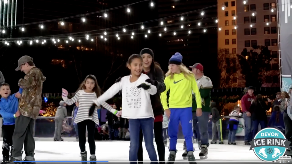 group of smiling patrons at Devon Ice Rink ice skating and all smiling